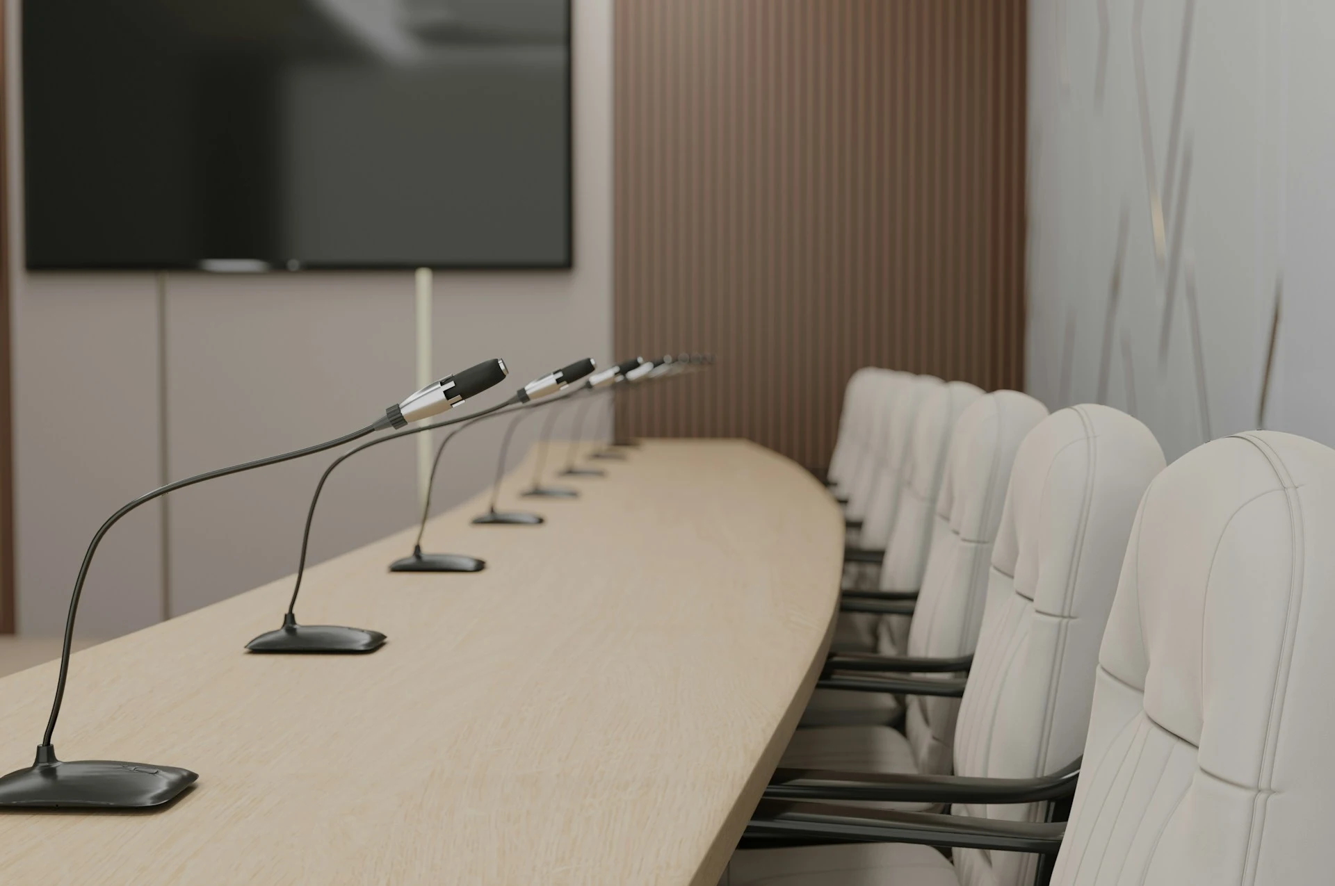 Sala conferenze con microfoni pronti sul tavolo dei relatori